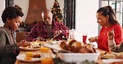 Buy stock photo Christmas lunch, parents and kids with eating in home for  festive feast, holiday celebration or hungry. People, african family and dining together at table for xmas tradition, brunch meal or bonding