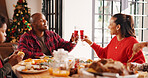 Christmas, lunch and parents with drinks cheers in home for celebration, festive feast and bonding. Food, african family and meal toast at dinner table for holiday tradition, xmas gathering or eating