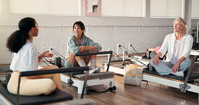 Buy stock photo Pilates, talking and trainer with women in studio for fitness advice, workout tips or exercise. Health club, instructor and people in conversation, chat or speaking on reformer machine for wellness