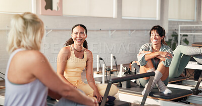 Buy stock photo Pilates, laugh and women in studio talking for fitness advice, workout tips and exercise in gym. Health club, instructor and people in conversation, chat and rest on reformer machine for wellness