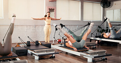 Buy stock photo Woman, coach and pilates with stretching legs at club, reformer or motivation at exercise class. Person, talk and guide for holistic fitness, training and flexibility with resistance band at gym
