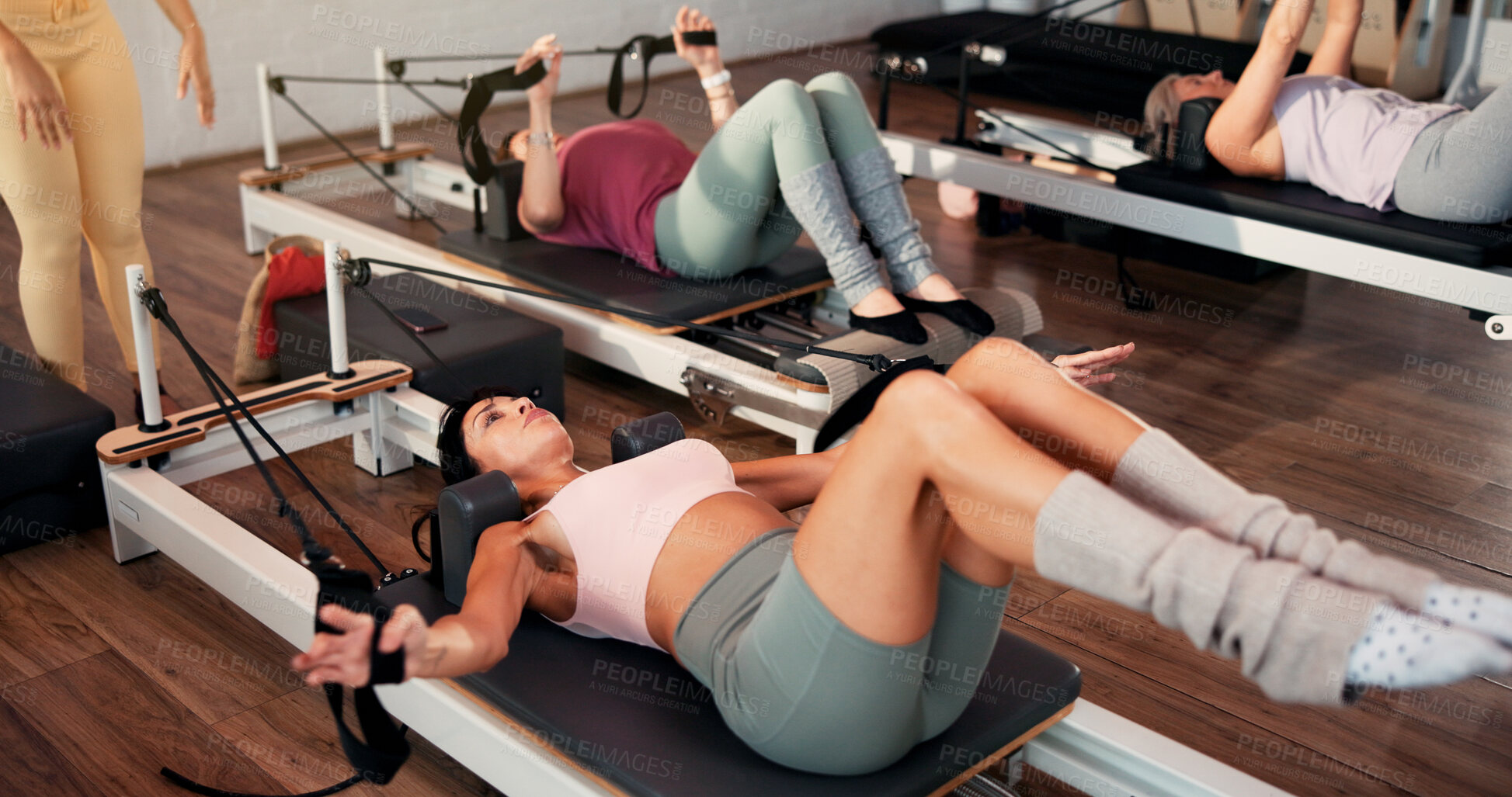 Buy stock photo Reformer, stretching and women in class, instructor and fitness with pilates training. Healthy people, coach or group in studio, machine or exercise with challenge, endurance or balance with wellness