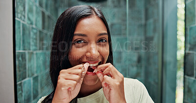 Buy stock photo Dental floss, portrait and smile of woman in bathroom of home for getting ready or morning routine. Mouth, oral hygiene and mirror with happy Indian person in apartment for daily teeth cleaning