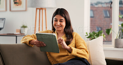 Buy stock photo Streaming, smile or Indian woman on sofa with tablet, online reading or video update on social media. Happy, scroll or girl in house with tech, e book subscription or multimedia browse on digital app