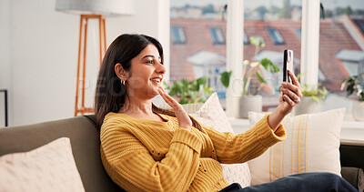 Buy stock photo Cellphone, video call and woman on sofa in home with communication, greeting and online conversation. Happy, waving and female person with phone for virtual discussion with networking in living room.