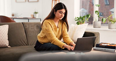 Buy stock photo Serious, woman and typing with laptop on sofa for research, online course or studying in home. Female person, student or elearning with technology for information, network service or connection