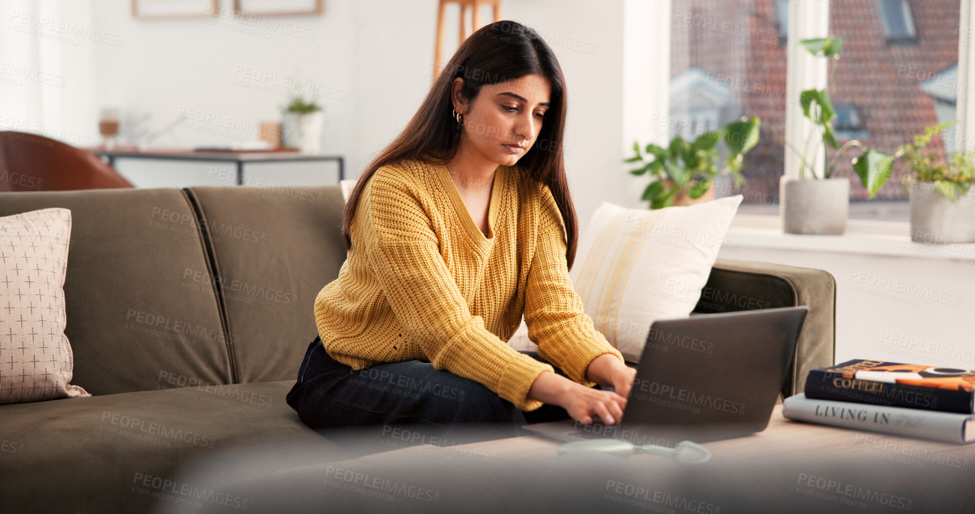 Buy stock photo Serious, woman and typing with laptop on sofa for research, online course or studying in home. Female person, student or elearning with technology for information, network service or connection
