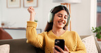 Happy woman, phone and dance on sofa, headphones and listen to music in living room at home. Person, smartphone and smile with rhythm, streaming subscription and mobile app on couch at apartment