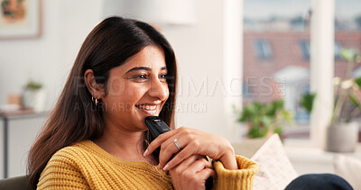 Buy stock photo Home, laugh and woman with remote, watching tv and streaming movies with subscription in living room. Comedy, online and Indian person with controller for entertainment, chill and comfortable on sofa