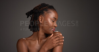 Buy stock photo Black woman, relax and studio with skincare for beauty or cosmetics on a gray background. Calm, female person or model with smile, shoulder or touch for dermatology, hygiene or shine on space