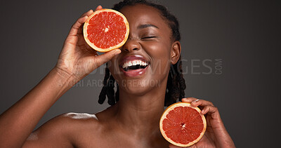 Buy stock photo Skincare, grapefruit and black woman in studio with hydration, health or organic facial glow. Vitamin c, space and African female person with citrus fruit for natural dermatology by gray background.