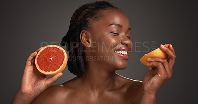 Buy stock photo Happy woman, beauty and smell grapefruit in studio, mockup space and vitamin c on dark background. African person, citrus fruit and thinking with scent, organic product and benefits with skincare