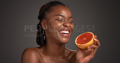 Buy stock photo Laugh, grapefruit and black woman with skincare in studio with natural, health or organic glow. Vitamin c, happy and African person with citrus fruit for dermatology hydration by gray background.