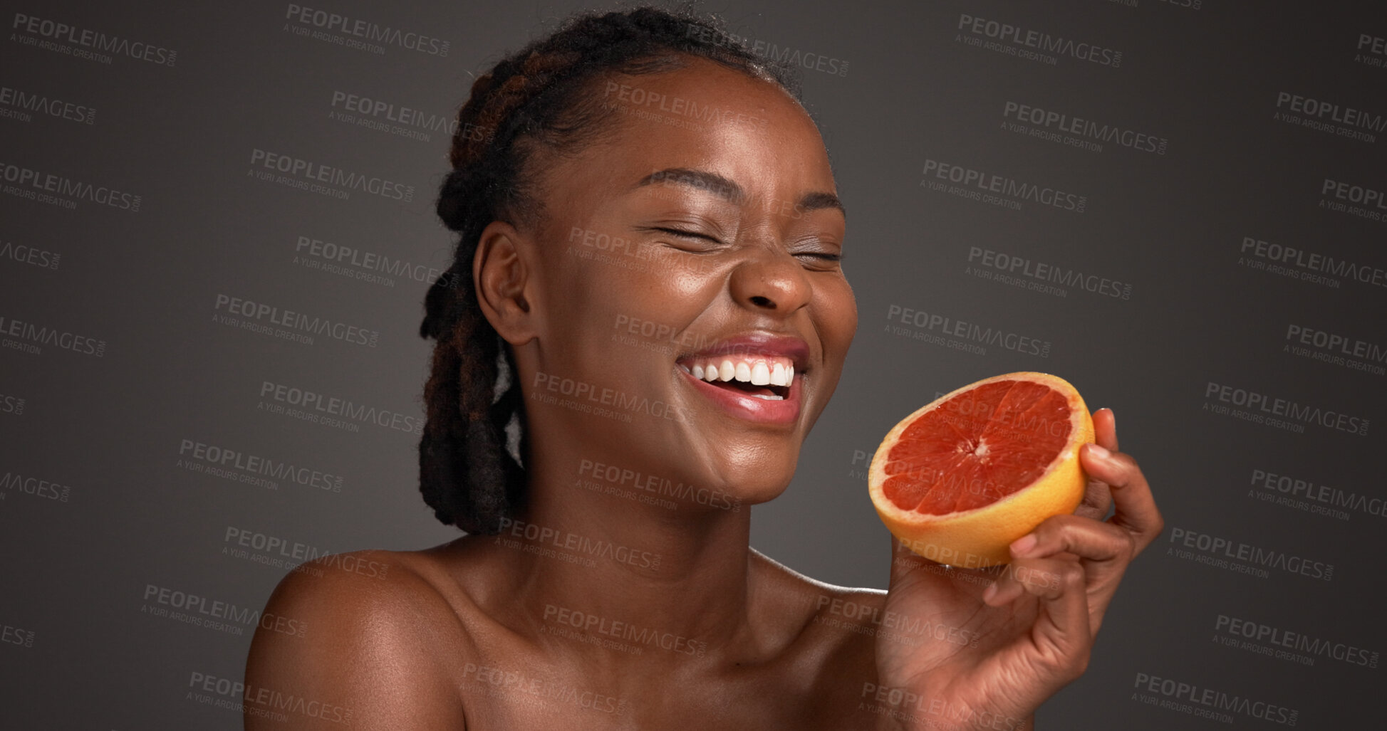 Buy stock photo Laugh, grapefruit and black woman with skincare in studio with natural, health or organic glow. Vitamin c, happy and African person with citrus fruit for dermatology hydration by gray background.