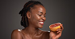 Black woman, skincare and happy with grapefruit in studio, mockup space and vitamin c on dark background. African person, citrus fruit and thinking with smile, organic product or benefits with beauty
