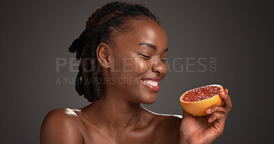Buy stock photo Black woman, skincare and happy with grapefruit in studio, mockup space and vitamin c on dark background. African person, citrus fruit and thinking with smile, organic product or benefits with beauty