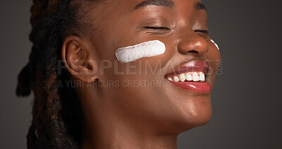 Buy stock photo Happy, black woman and studio with lotion for skincare or moisturizer on a gray background. Female person, model or smile with face cream, SPF or beauty cosmetics for anti aging, smooth or soft skin