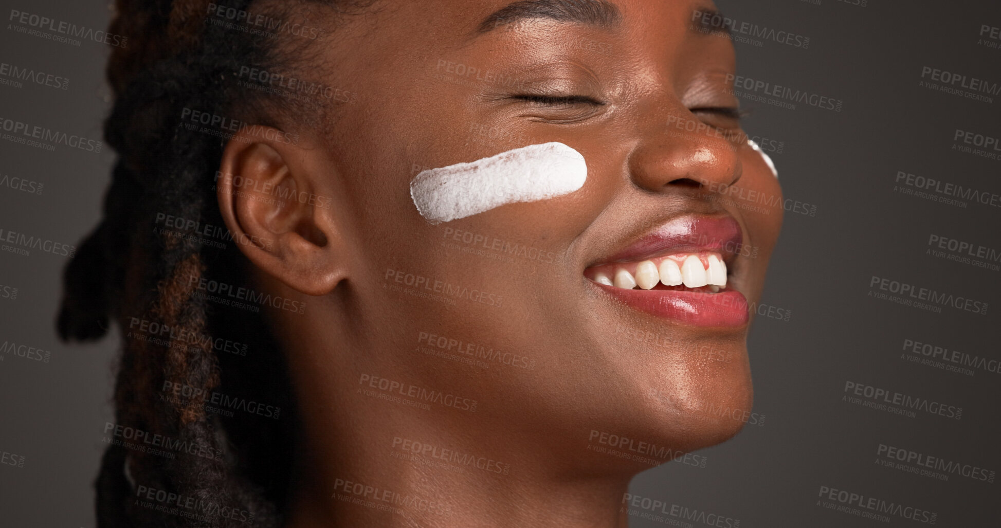 Buy stock photo Happy, black woman and studio with lotion for skincare or moisturizer on a gray background. Female person, model or smile with face cream, SPF or beauty cosmetics for anti aging, smooth or soft skin