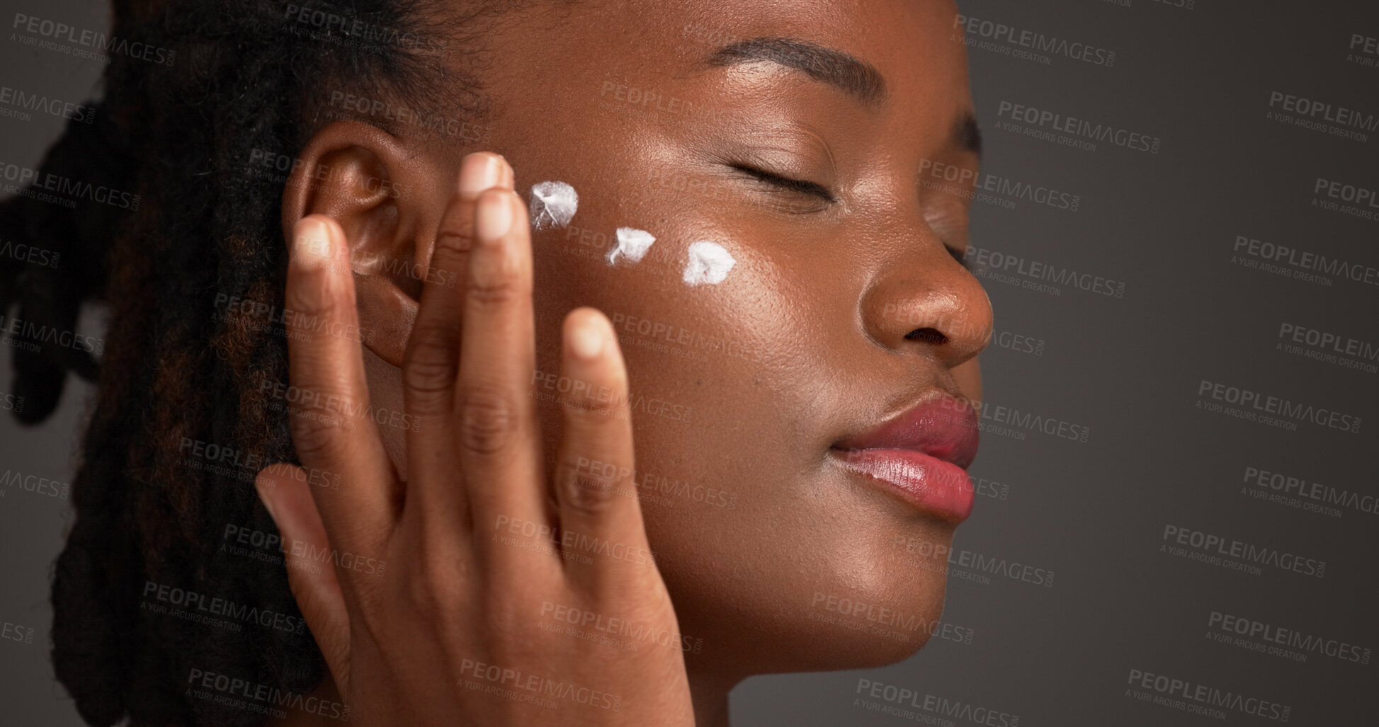 Buy stock photo Black woman, studio and skincare with lotion for moisturizer or face cream on a gray background. Female person, model or applying product with beauty cosmetics for anti aging or soft skin on space