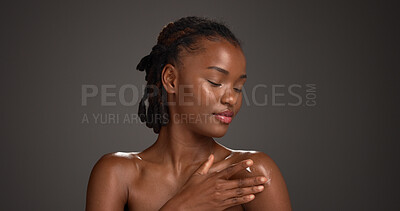 Buy stock photo Beauty, skincare or black woman with lotion in studio, hydration or wellness benefits in apply. Shine, dermatology or person with moisturizing glow cream, body care or mockup space on gray background
