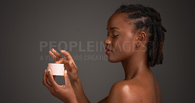 Buy stock photo Black woman, skincare and cream with tub in studio, test and mock up space on dark background. African girl, beauty and container with lotion, cosmetics and application for dermatology benefits