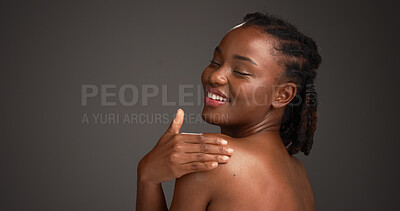 Buy stock photo Black woman, skincare and touch shoulder in studio, wellness shine or healthy glow for dermatology. Body care, flawless skin and person with mockup space, smooth or soft texture on gray background