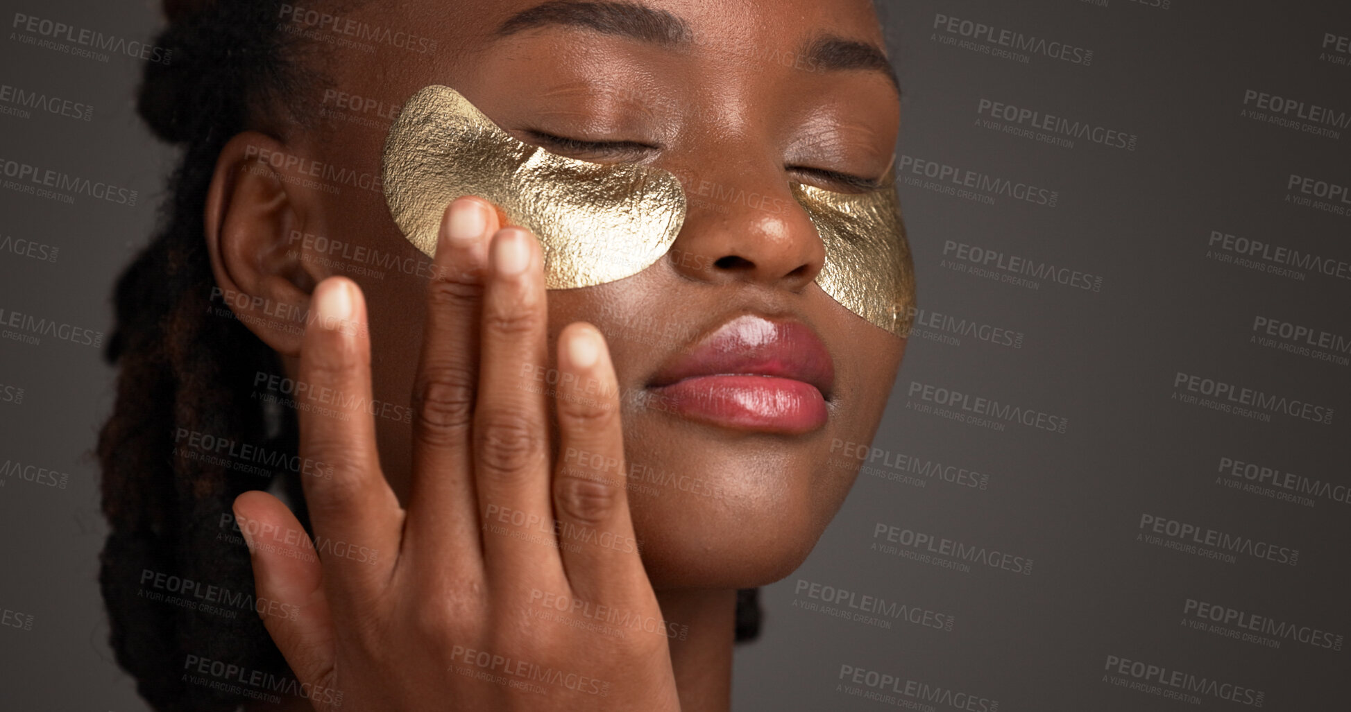 Buy stock photo Beauty, eye patch and facial with black woman on studio space for cosmetics or dermatology. Apply, gold product and skincare with African model isolated on gray background for antiaging treatment