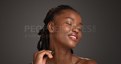 Buy stock photo Happy, black woman and skincare with gua sha for facial massage on a gray studio background. Female person, model or beauty with spa tool for treatment, lymphatic drainage or dermatology on space