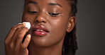 Beauty, dropper and lip serum with black woman in studio for cosmetics or dermatology routine. Hydration, mouth moisturizer and skincare with African model isolated on gray background for treatment