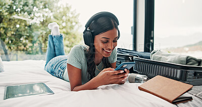 Buy stock photo Music, phone and luggage with woman in bedroom for travel blog, streaming service or typing. Radio subscription, trip research and resort review with person and headphones in house rental for contact
