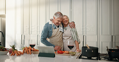 Buy stock photo Cooking, tablet and senior couple hug in kitchen for lunch, supper and prepare food for bonding in home. Love, retirement and tech with old man and woman for meal prep, online recipe and wine