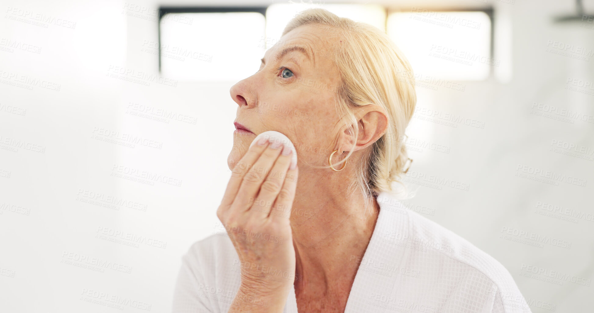 Buy stock photo Mature woman, cotton pad and bathroom with skincare routine, cleaning and exfoliate at house. Person, product and swab for dermatology, hygiene and cosmetics for beauty, grooming or wellness in home