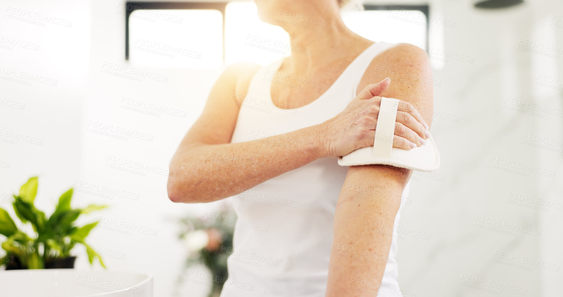Buy stock photo Home, skincare and old woman in bathroom, dry brush and lens flare with hygiene. Morning routine, pensioner and senior person with exfoliation, cleaning and wellness with healthy skin and body scrub