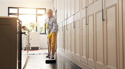 Buy stock photo Cleaning, kitchen and senior woman with broom for hygiene, housekeeping and floor maintenance. Retirement, flare and mature person sweeping dust for wellness, dirt removal and chore routine in home