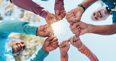 Buy stock photo Senior people, hands together and fist for fitness, solidarity or collaboration support in outdoor park. Blue sky, happy group and friends for motivation goals, mission or workout exercise below