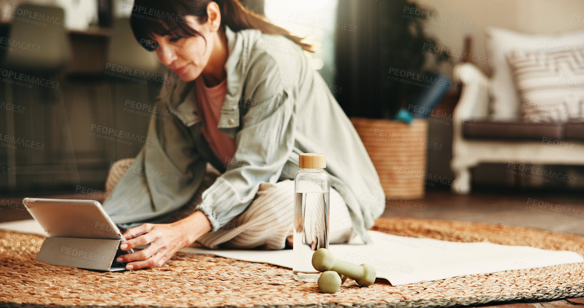 Buy stock photo Dumbbells, water and yoga woman on floor in living room of home for online holistic course. Hydration, exercise and weights with mature yogi person in apartment for virtual health class on tablet