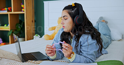 Buy stock photo Student, headphones and fidget toy with laptop on bed for adhd, stress and reading notes for exam prep. Girl, elearning and sensory tool for learning support, education relief and concentrate in home