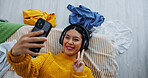 Selfie, peace sign and headphones with woman in bedroom for social media, relax and profile picture. Photography, post update and music with above of person on bed in home for memory and vlog