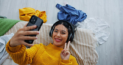 Buy stock photo Selfie, peace sign and headphones with woman in bedroom for social media, relax and profile picture. Photography, post update and music with above of person on bed in home for memory and vlog