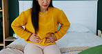 Cramps, menstruation and woman in bedroom with massage, discomfort or stomach ache in symptoms. Health, pelvic pain or girl in house with belly rub, endometriosis or soothe abdominal tension on cycle