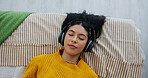 Home, above and woman with headphones, relax and listening to music, sleeping and sound. Apartment, audio and person with break, resting and playlist album with radio, comfort and podcast with song