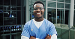 Medical, portrait or black man in hospital at night, arms crossed or career pride in healthcare. Bokeh, glasses or nurse in clinic with confidence, about us or general practitioner in overtime.