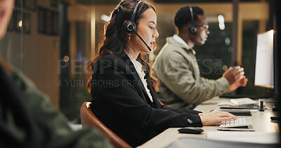 Buy stock photo Woman, call center and typing with headset at night for customer service or consulting at office. Female person, employee or agent talking for communication, helpdesk and overtime at workplace