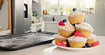 Cupcakes, kitchen and baking with fruit for sweet dessert, recipe or pastry creation in home. Empty, baked and muffin with icing, strawberries or blueberries for hospitality or cake serving on plate