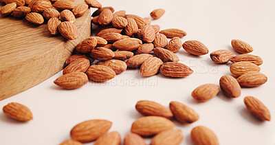 Buy stock photo Diet, health and almonds on table, food and natural nutrition for wellness. Wooden counter, organic snacks and nuts for  vegetarian protein, vegan and vitamins with magnesium mineral for benefits