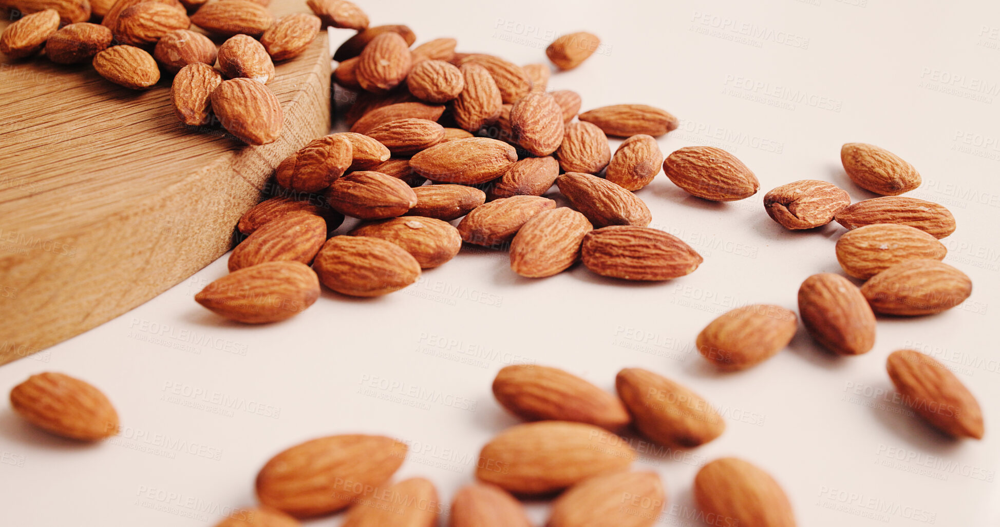 Buy stock photo Diet, health and almonds on table, food and natural nutrition for wellness. Wooden counter, organic snacks and nuts for  vegetarian protein, vegan and vitamins with magnesium mineral for benefits