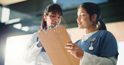 Buy stock photo Doctors, women and meeting with clipboard in clinic, medical record and advice for patient care plan. Healthcare, expertise and people review report for diagnosis help, treatment ideas and low angle