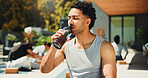 Drinking, outdoor and man with water at yoga class for break, relax or recovery on wellness retreat. Calm, rest and male person with healthy beverage for hydration at pilates session on holiday.