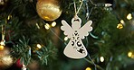 Christmas, decoration and festive with angel on tree in home for celebration, event or tradition. Background, holiday and wallpaper with ornament in apartment for aesthetic, vacation or winter season