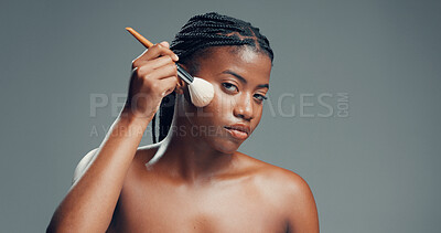 Buy stock photo Makeup, beauty and portrait of black woman with brush in studio for shine, foundation or glow. Face, apply cosmetics and model with product for makeover, change and powder on gray background space